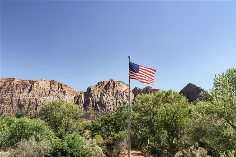 American flag waving in front of mountains.