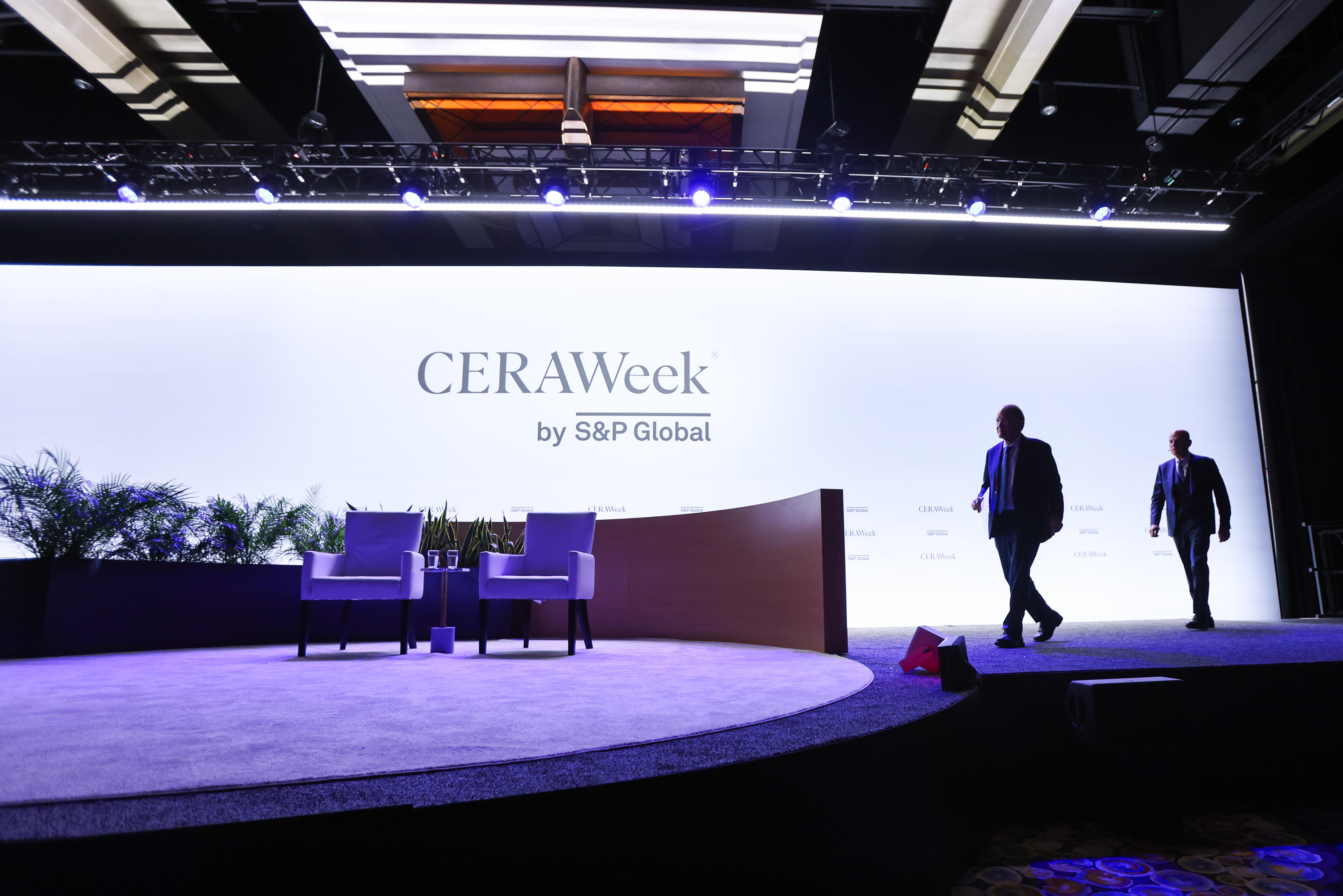 CERAWeek 2026 banner with two people walking in front of it.