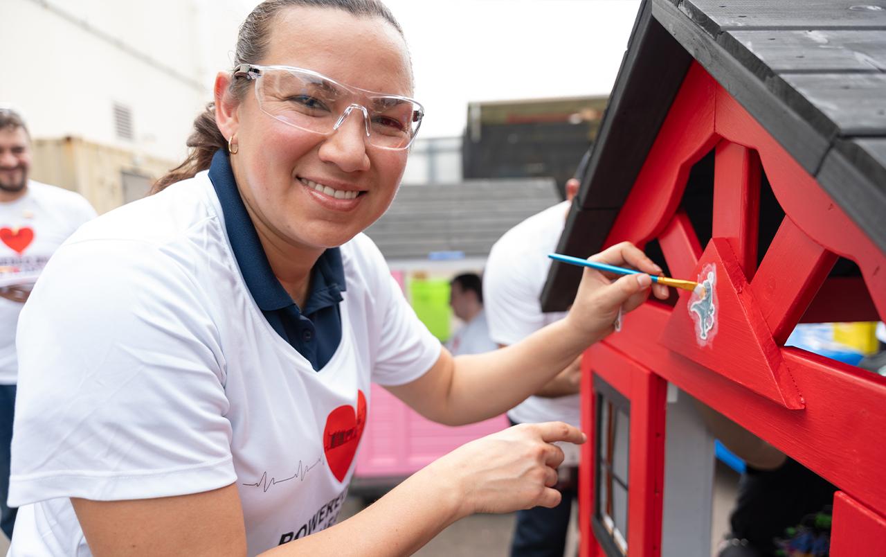 Mitsubishi Power employees painting playhouses for Habitat for Humanity