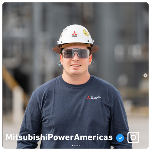 Mitsubishi Power Employee smiling in front of blurred power plant
