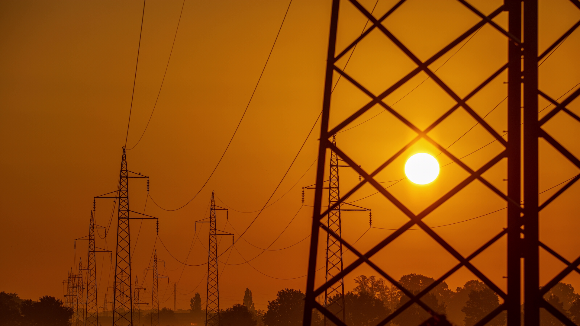 Sun rising behind a power tower