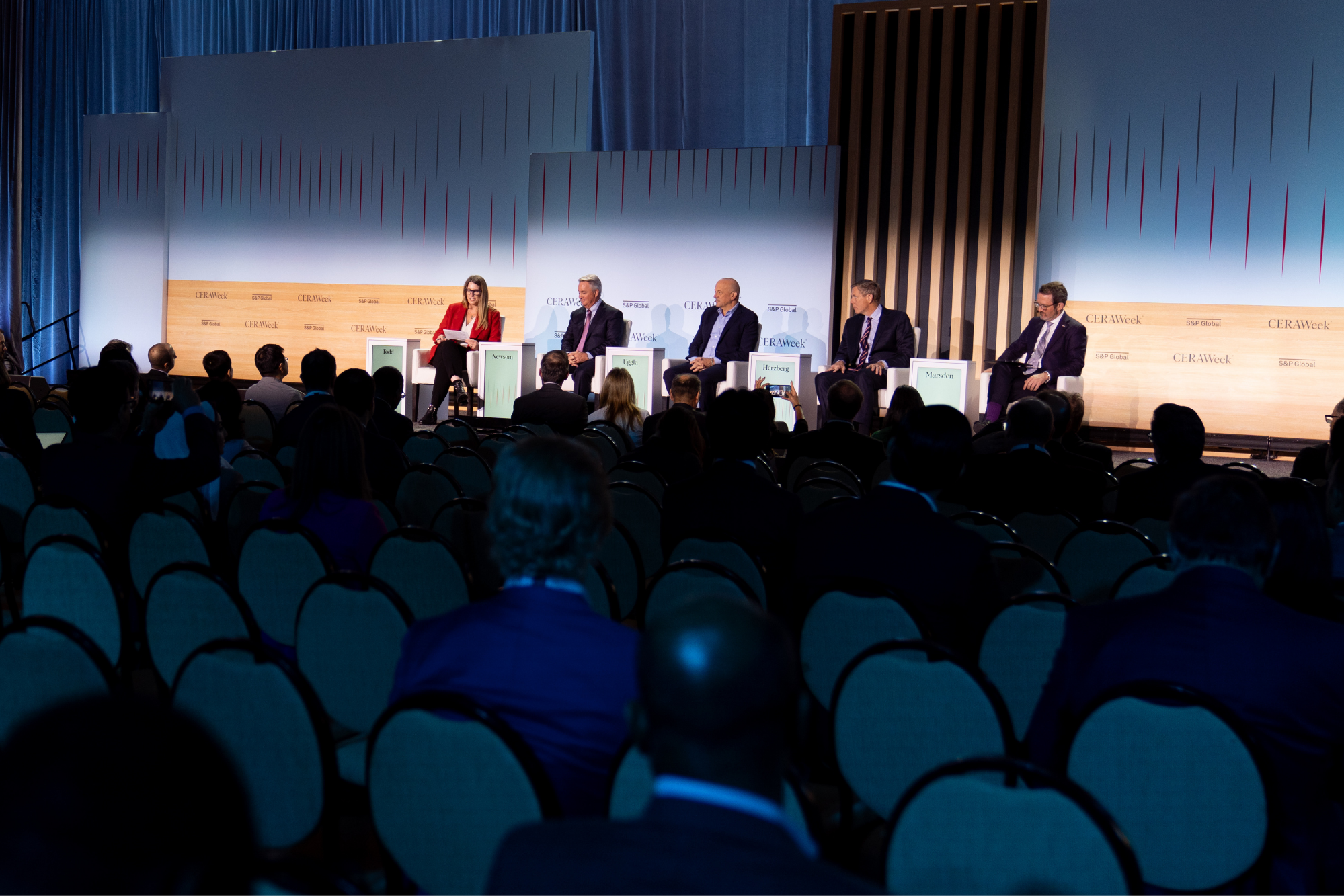 Wide shot of a CERAWeek conference panel with multiple speakers seated on stage and an audience listening.